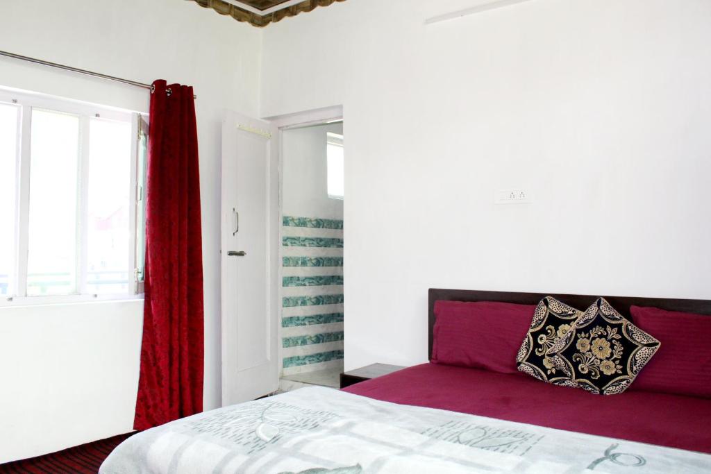 1 dormitorio con 1 cama con manta roja y ventana en Piece Of Paradise Bhaderwah en Bhadarwāh