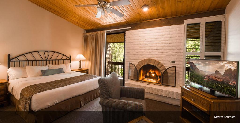 Arroyo Roble Resort at Oak Creek في سيدونا: غرفة نوم بسرير ومدفأة
