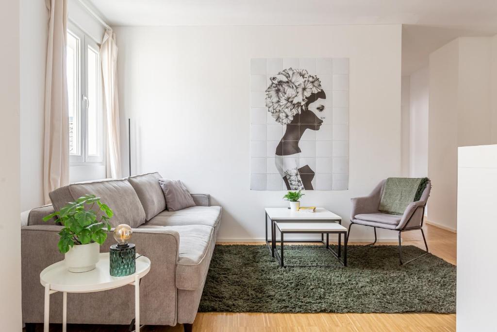 Global Living - Design Apartment I Central I Smart-TV I Kitchen I Berlin في برلين: غرفة معيشة مع أريكة وكرسي