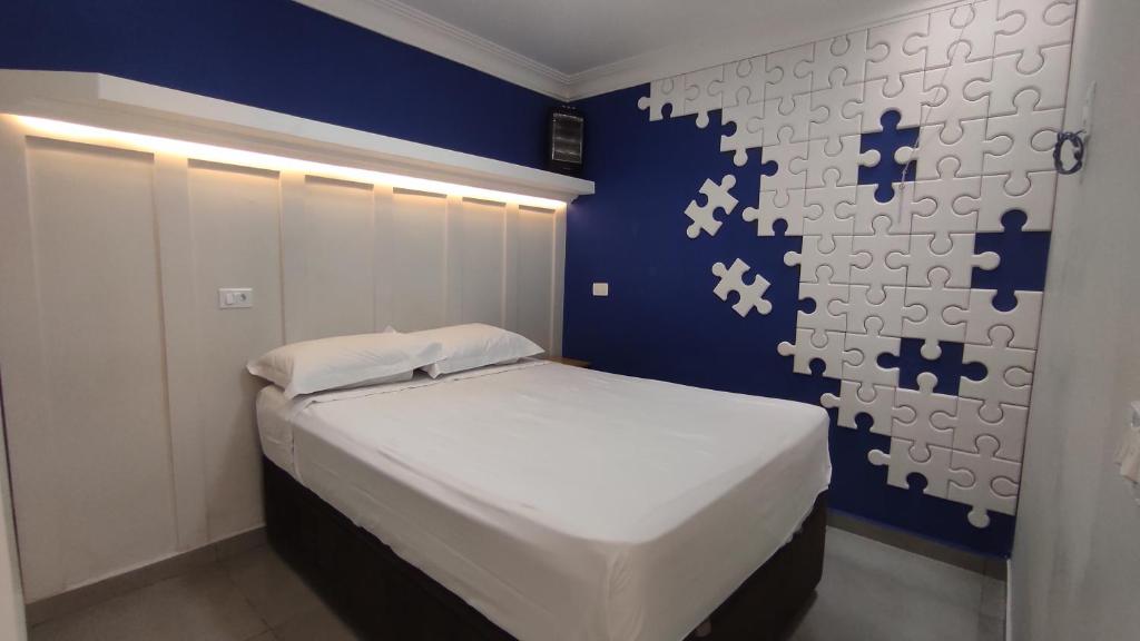a bedroom with a bed with a blue wall at Family House - Curitiba in Curitiba