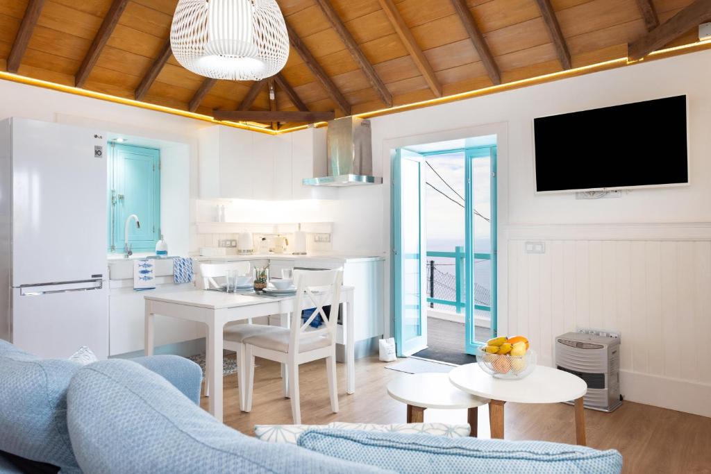 un soggiorno con un divano blu e una cucina di casa mo Tenerife a Garachico
