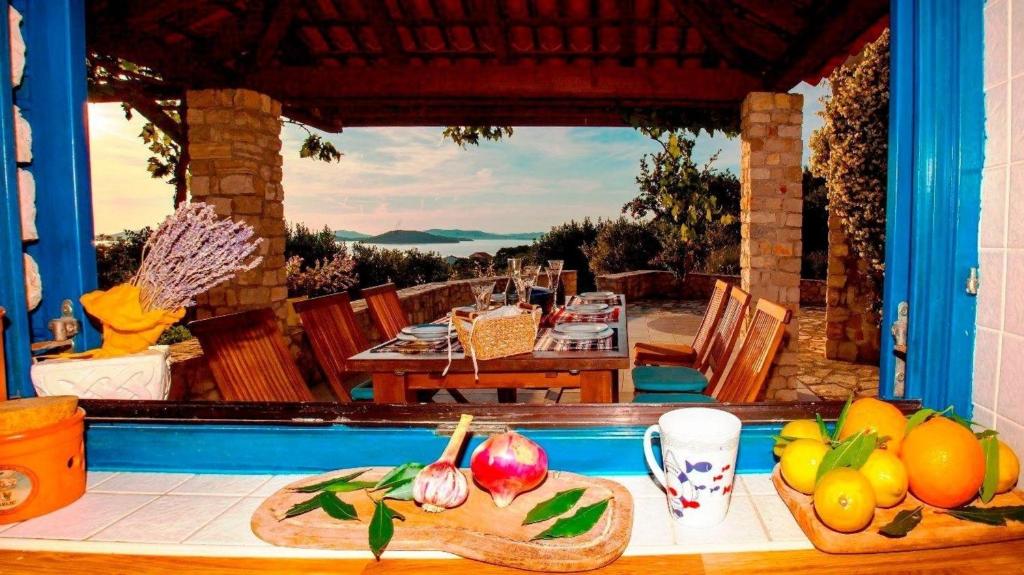 a table with fruits and vegetables on top of a house at Freistehendes Ferienhaus in Zlarin mit Sonniger Terrasse und Panoramablick in Zlarin