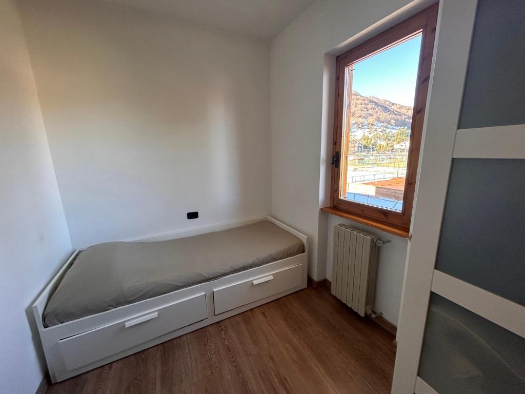 Kleines Zimmer mit einem Bett und einem Fenster in der Unterkunft Casa dello sport in Roccaraso