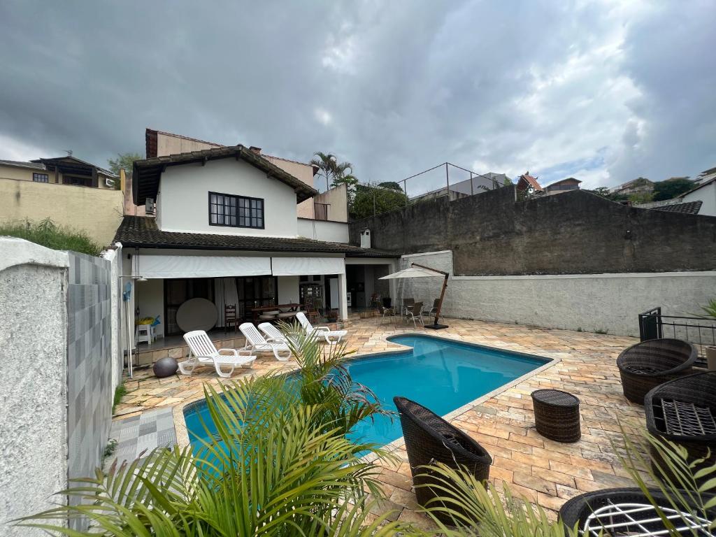 a swimming pool in front of a house at Portal_105 in Juiz de Fora