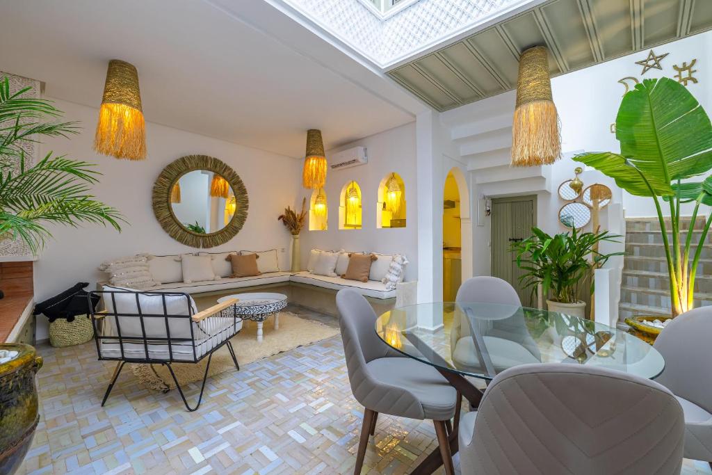 a living room with a glass table and chairs at Riad Zahra b&b your private house in Marrakech in Marrakech