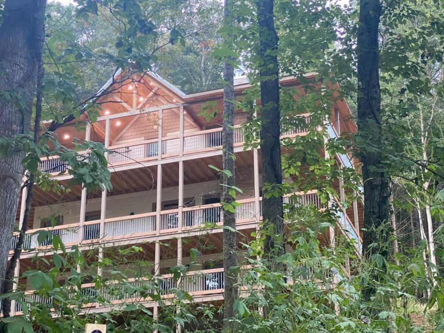 a large log cabin in the woods with trees at The Grand Tennessean Cabin- Four Bedroom Luxury Cabin in the Mountains in Pigeon Forge