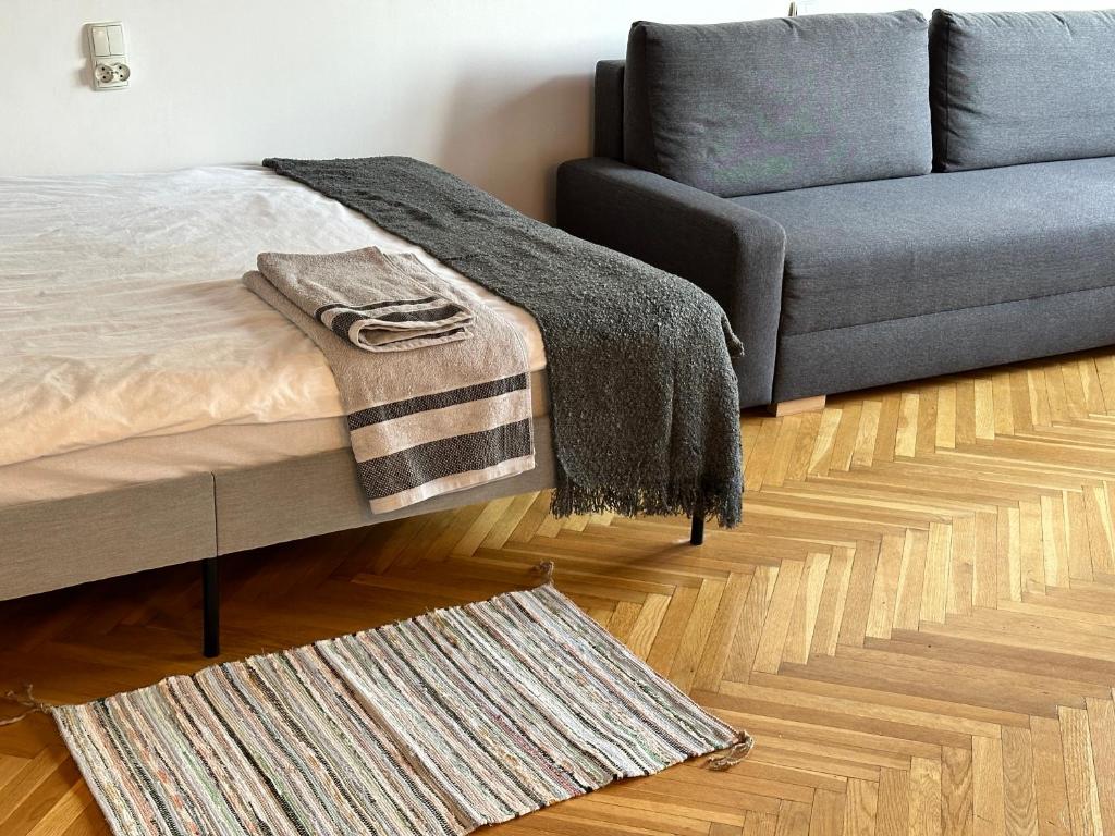 - une chambre avec un lit, un canapé et un tapis dans l'établissement APART WAWA app 38 WiFi 600 Mbit, à Varsovie