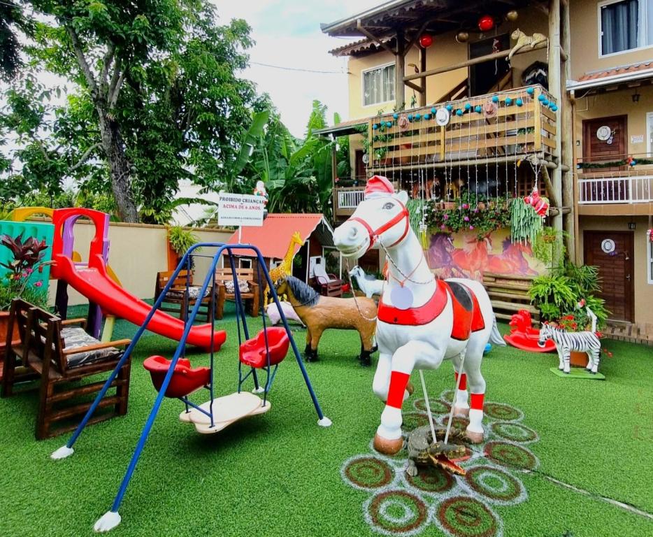 um parque infantil com um cavalo de brinquedo e um escorrega em Pousada Alegria do Cowboy em Penha