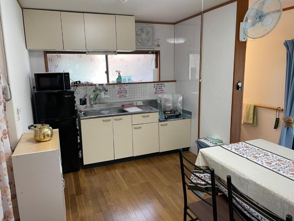 eine kleine Küche mit Spüle und Kühlschrank in der Unterkunft Yoka House - Vacation STAY 46247v in Tokunoshima