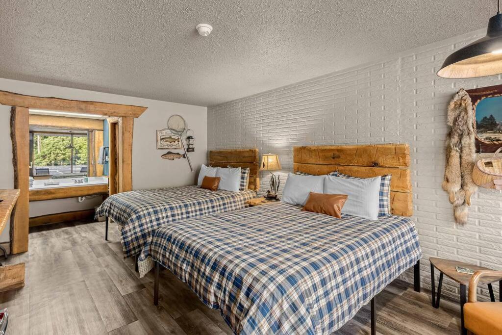 a bedroom with two beds and a window at Stonegate Lodge Salt Water Pool2 Queen Beds Fire Pits Fast WiFi Room #205 in Eureka Springs