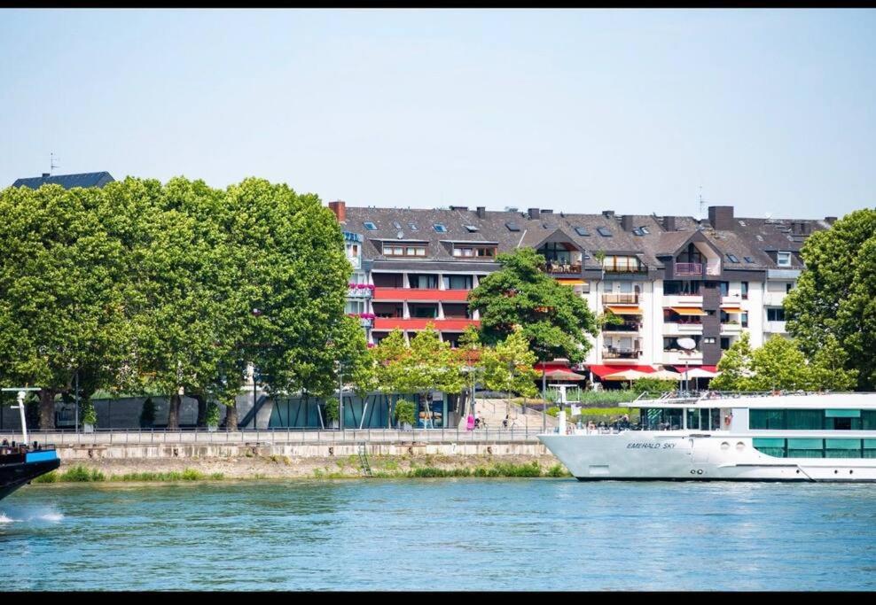 a boat on a river with buildings in the background at Rheinblick Apartment in Koblenz