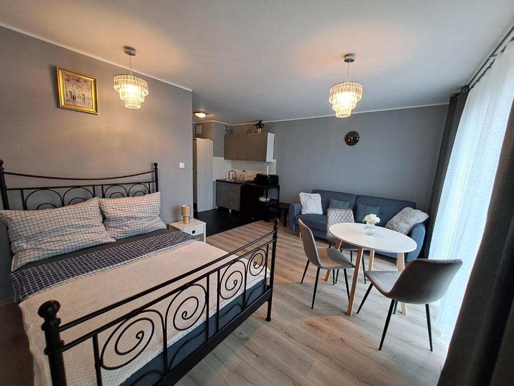 ein Schlafzimmer mit einem Bett und ein Wohnzimmer in der Unterkunft Apartament Kryształowy in Stettin