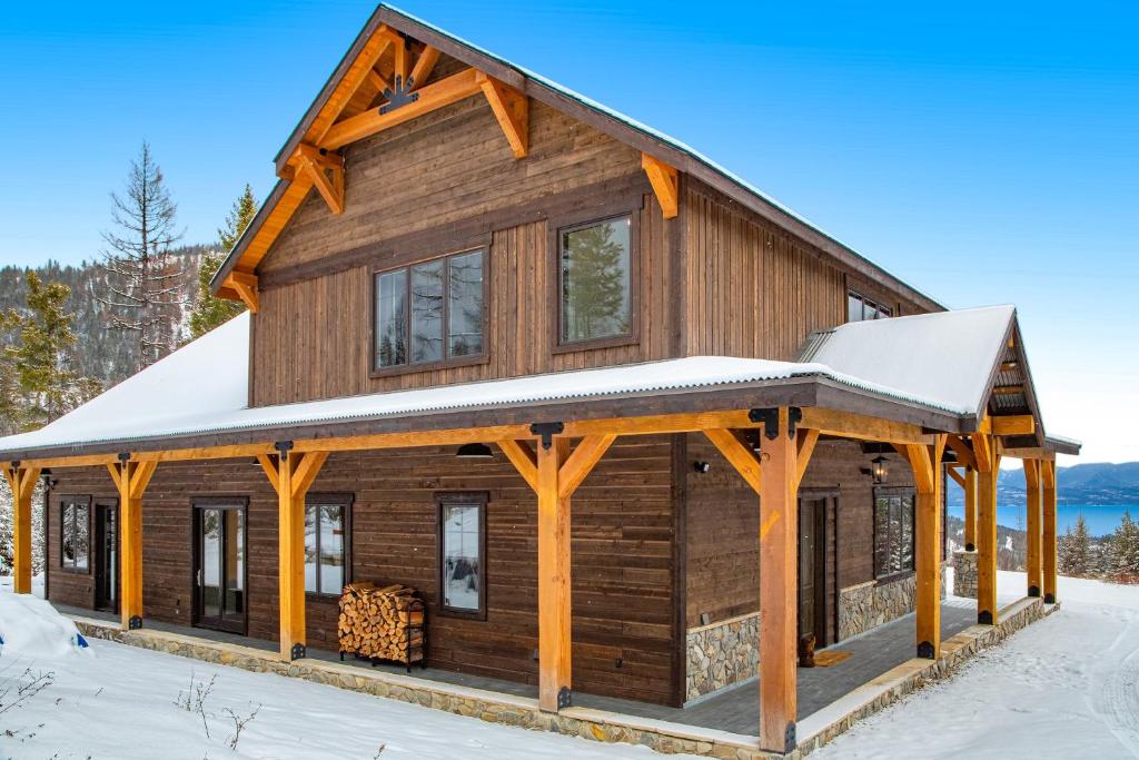 uma cabana de madeira com um telhado coberto de neve em La Tierra Lodge em Lakeside