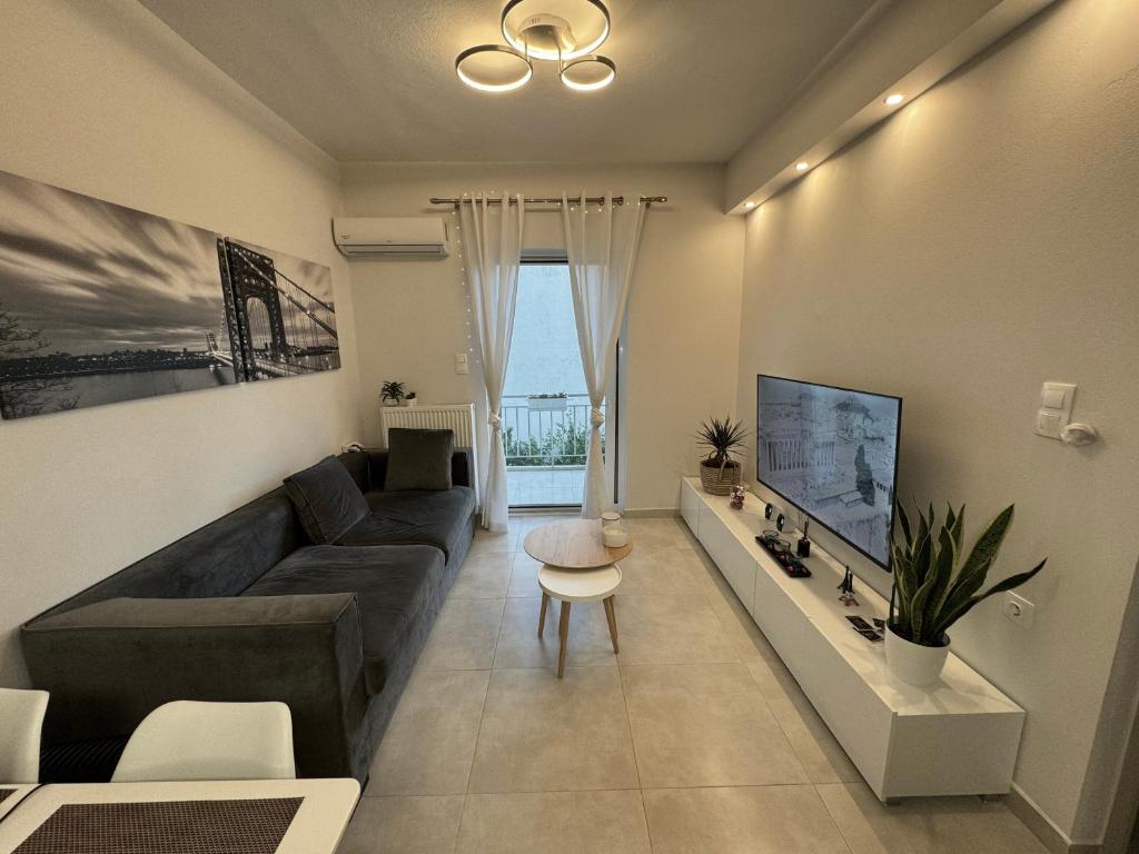 een woonkamer met een bank en een tv bij Your ideal stay in Athene
