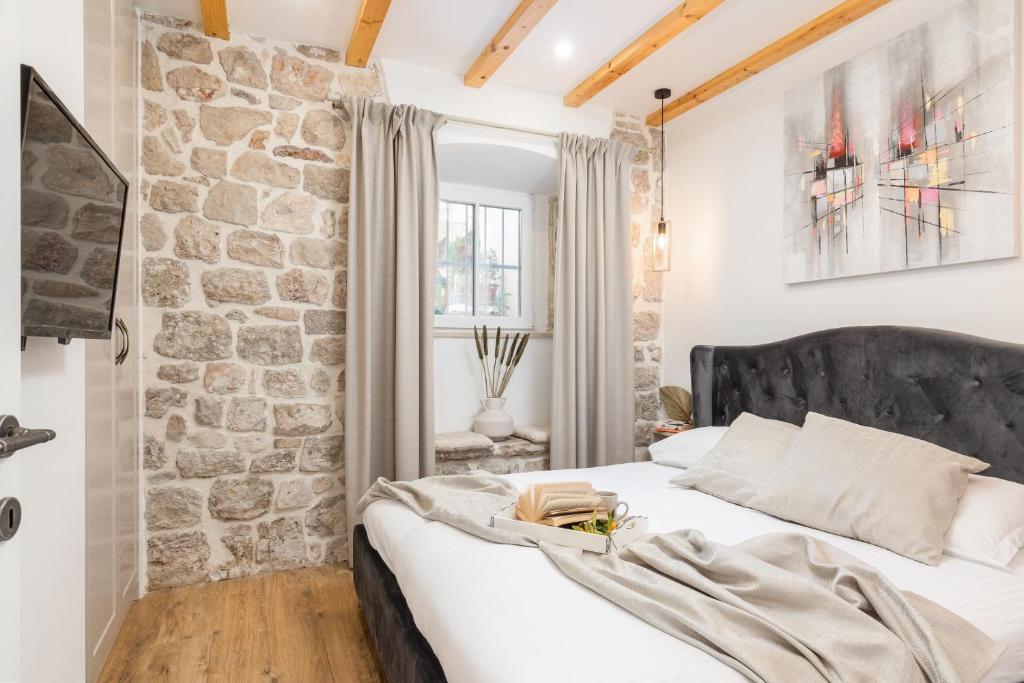 Cama en habitación con pared de piedra en Nono's House I, en Dubrovnik