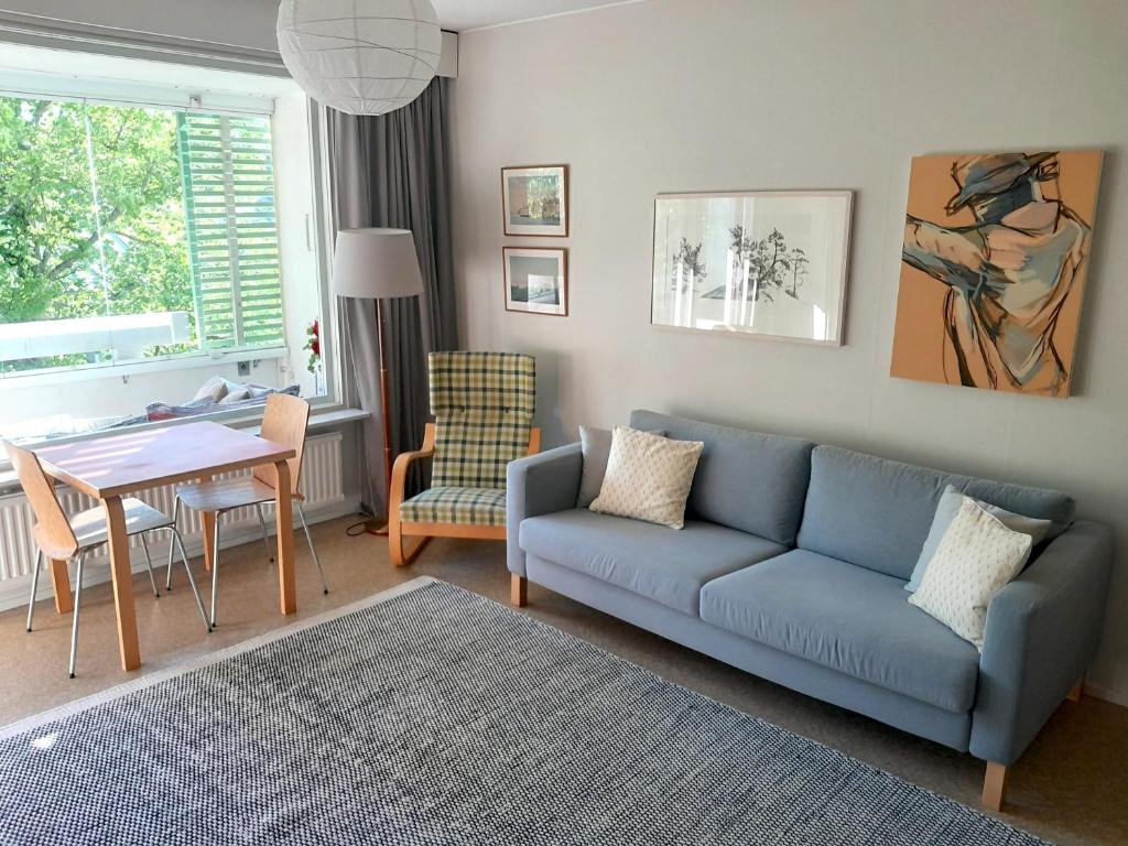 a living room with a blue couch and a table at Peaceful apartment on Sofiankatu Turku Center Free parking in Turku