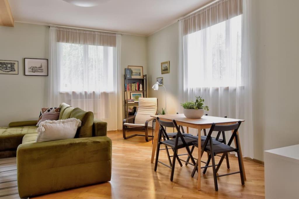 a living room with a table and a couch at Serene 1BR with Sauna & Private Entrance in Tallinn
