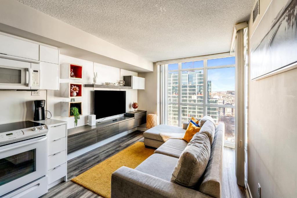 sala de estar con sofá y ventana grande en Beautiful Condos By CN Tower en Toronto