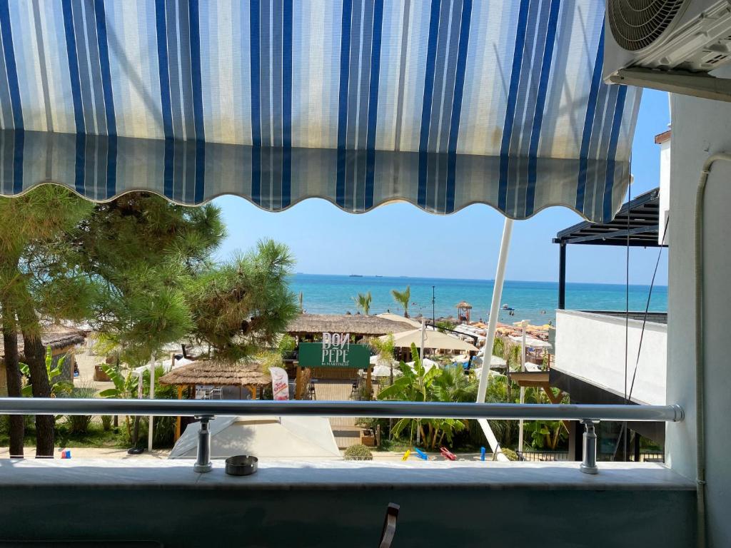 a view of the beach from a room with a window at Pandora's Seaview Apartment in Durrës