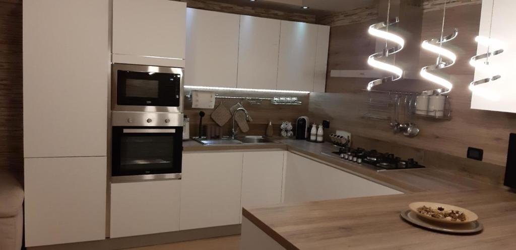 a kitchen with white cabinets and a stove top oven at Mobilheim für 2 Personen 2 Kinder ca 55 qm in Abano Terme, Norditalien Venetien in Abano Terme