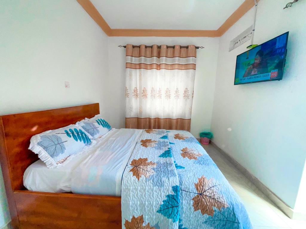 a bedroom with a bed with a blue comforter at Agape House in Kisoro
