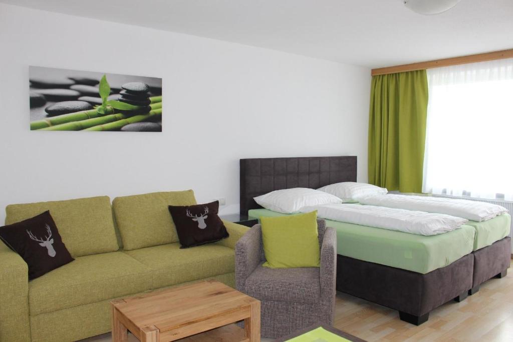 a living room with a bed and a couch and a table at Studio für 3 Personen ca 34 qm in Kaprun, Salzburger Land Kapruner Tal in Kaprun