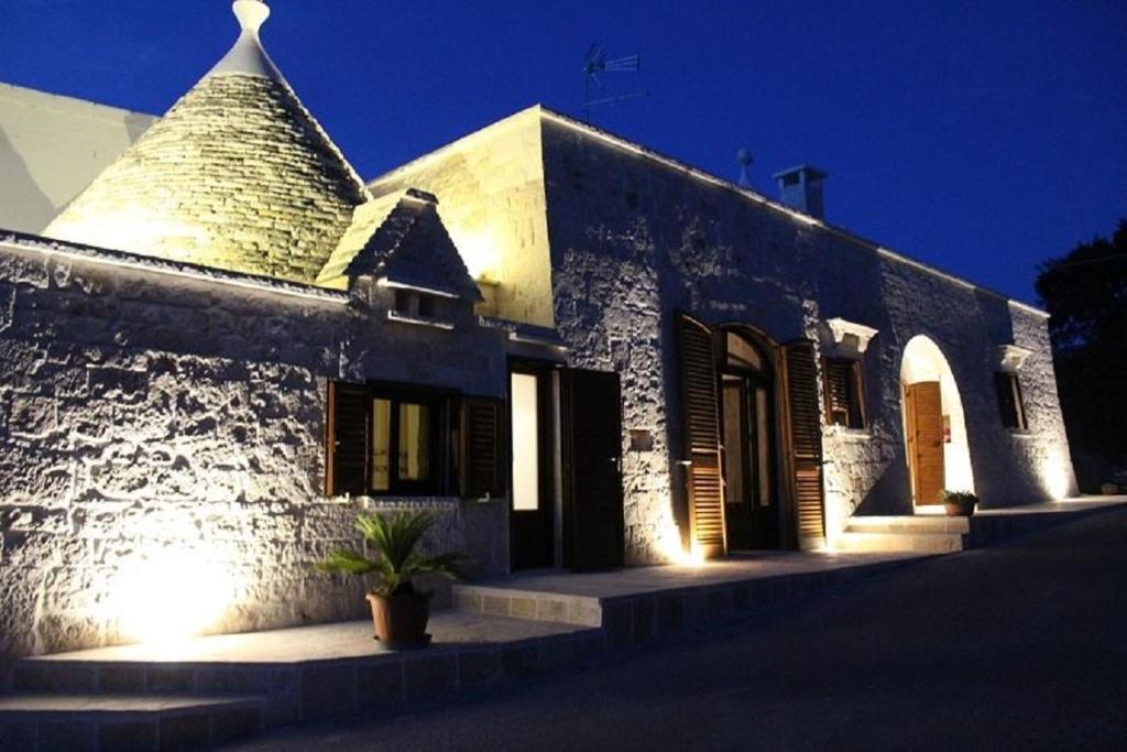 a white brick building with a pointed roof at Trulli Sulla Valle in Locorotondo