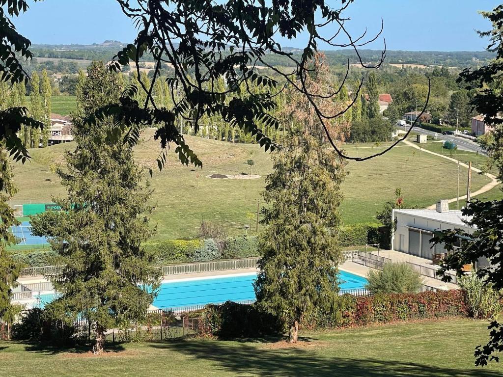 una imagen de una piscina con dos árboles en Mobilhome, en Castillonnès