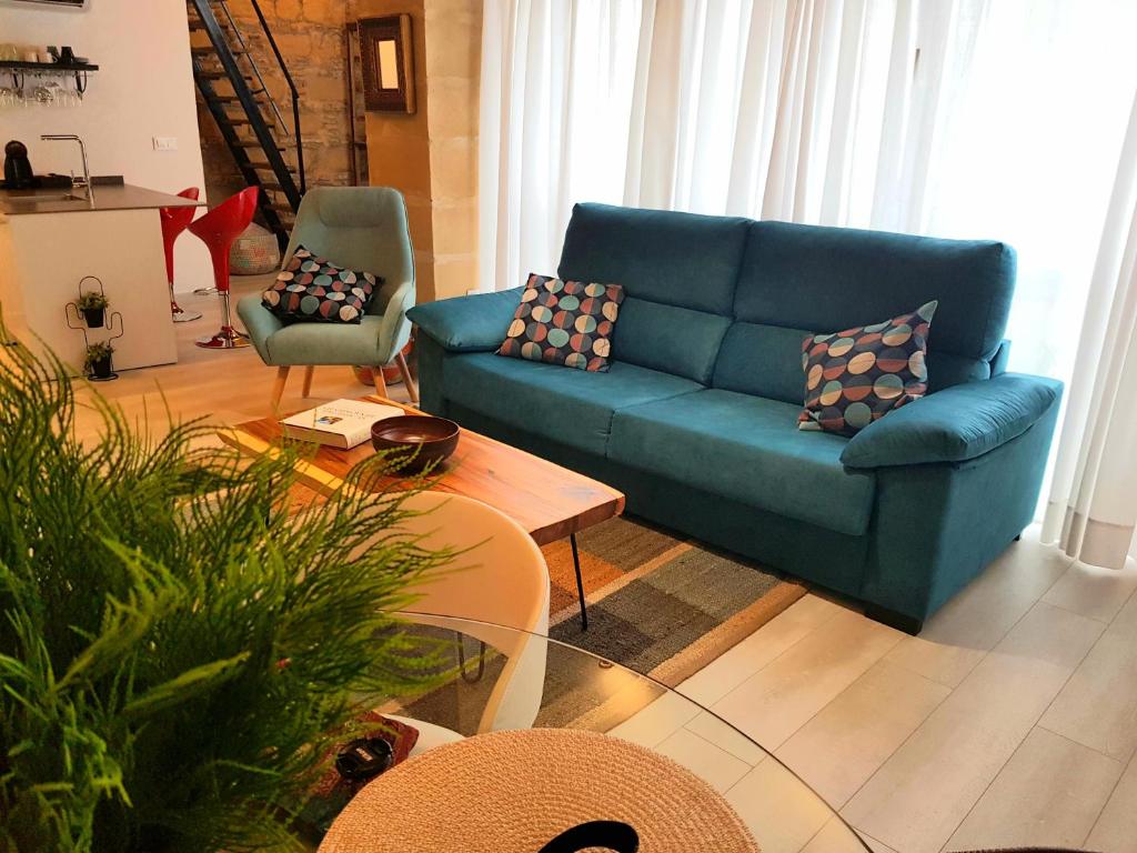 a living room with a blue couch and a table at Loft en casco histórico La Pintora - Parking publico opcional in Jerez de la Frontera