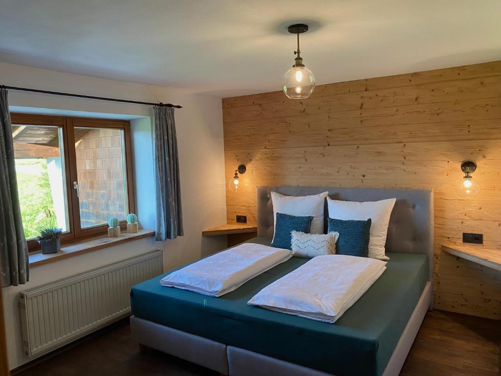 - une chambre avec un lit et un mur en bois dans l'établissement Bergromantik Apartments Fritzenlehen, à Berchtesgaden