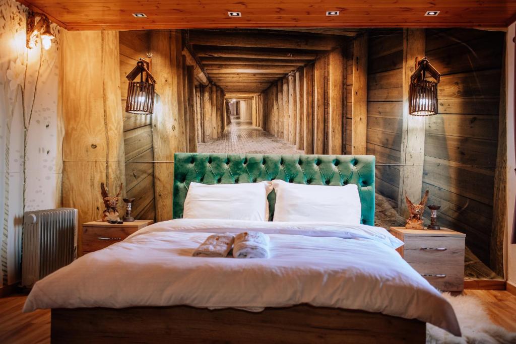 um quarto com uma cama grande e uma cabeceira verde em Keshtjella Xhabeqos em Tirana