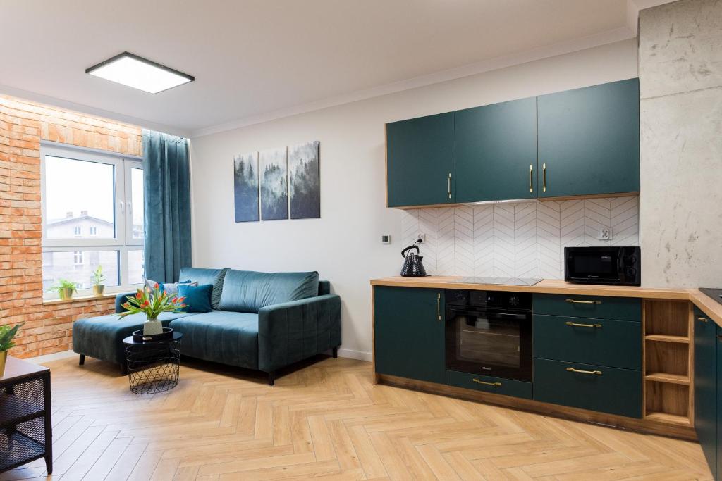 a living room with a couch and a kitchen at Witkacy Apartament in Słupsk