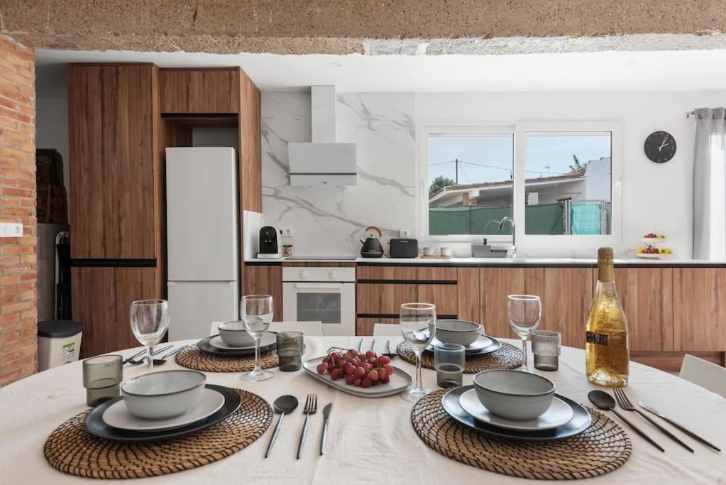 a kitchen with a table with plates and wine glasses at Bombonera 2 Jacuzzi in Catadau