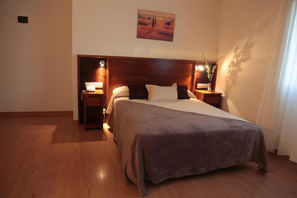 a bedroom with a large bed and two night stands at Hotel San Cibrao in San Ciprián de Viñas