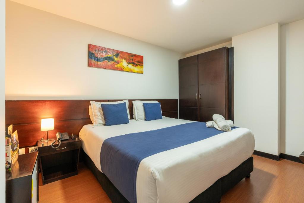 Habitación de hotel con cama grande con almohadas azules en Hotel Bogota Resort, en Bogotá