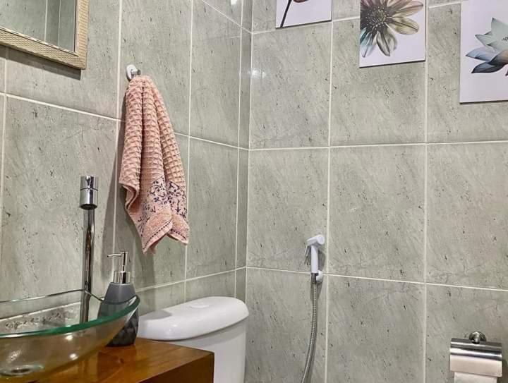 a bathroom with a toilet and a glass sink at Aconchego de geriba in Búzios