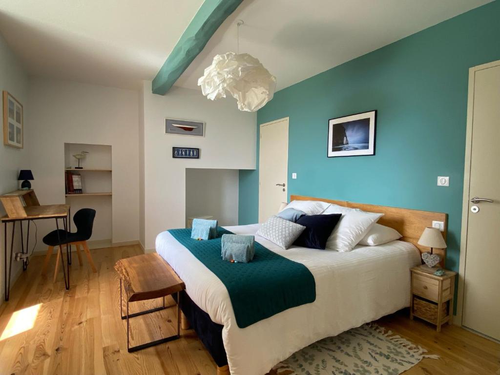 a bedroom with a large bed with blue walls at Les Chambres des 3 Chouettes in Sepx