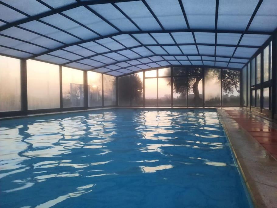 una piscina cubierta con un gran edificio con ventanas en Maison/Parking Privé/Piscine/Wifi/Canal du midi, en Béziers