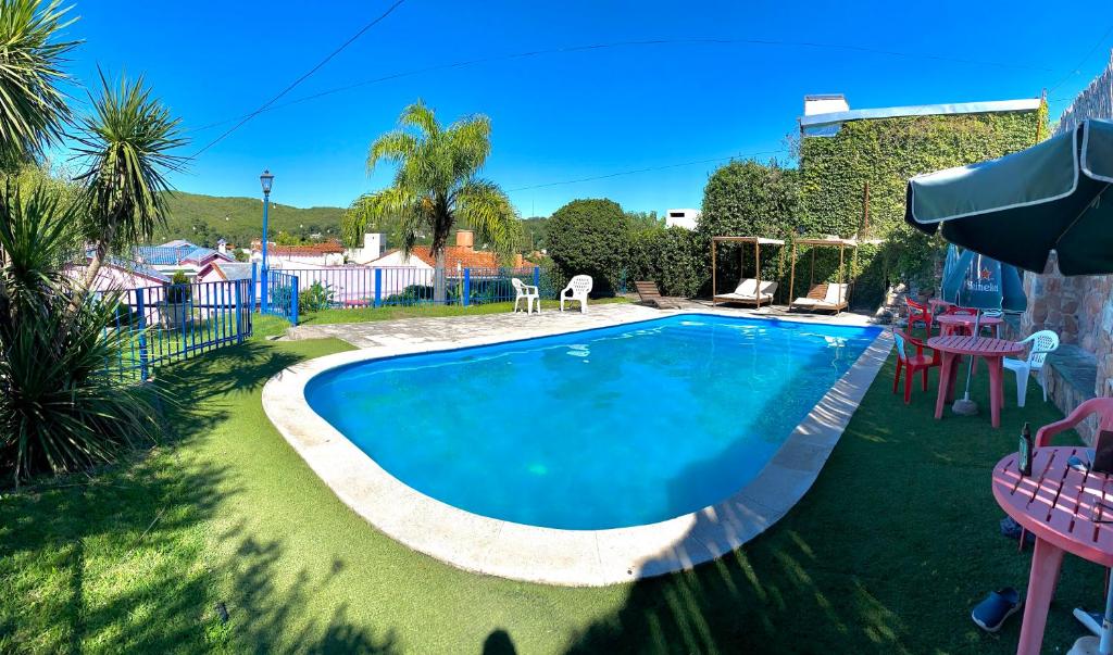 een zwembad in een tuin met tafels en stoelen bij Hotel de France Rio Ceballos in Río Ceballos
