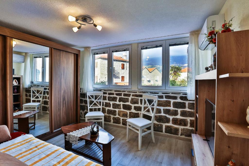 uma sala de estar com uma parede de tijolos em Basilica Apartments em Budva
