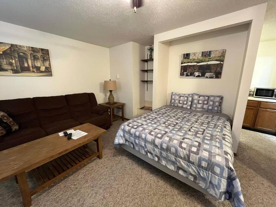 ein Wohnzimmer mit einem Bett und einem Sofa in der Unterkunft 201 E Veterans St Apt G by Patriot Properties in Tomah