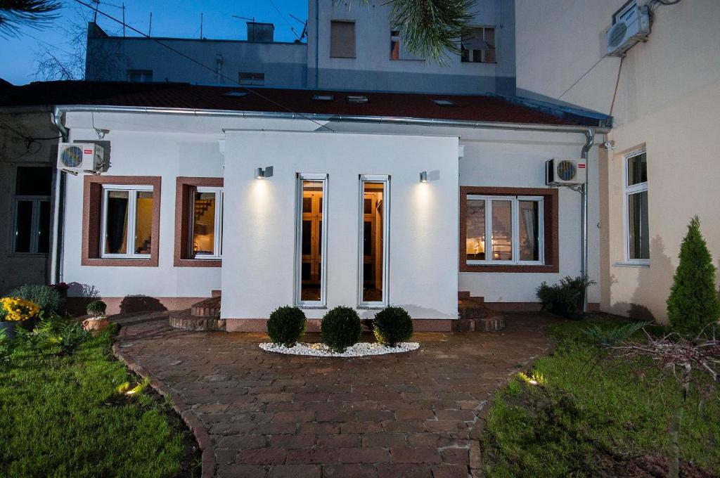 una casa bianca con un vialetto di mattoni di Green and Blue Garden Apartments a Belgrado