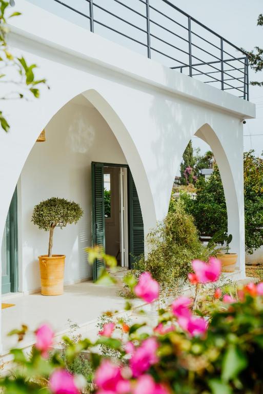 a white house with pink flowers in front of it at Sotiris House in Kazaphani