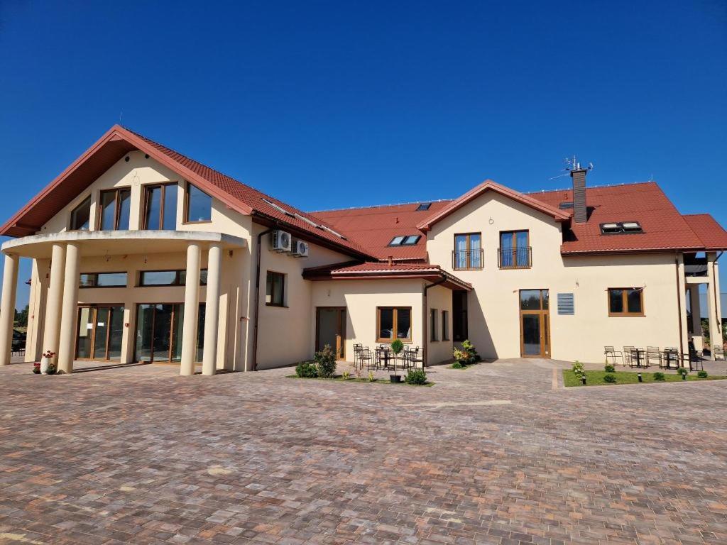 Villa Nova في Szuminka: بيت ابيض كبير بسقف احمر
