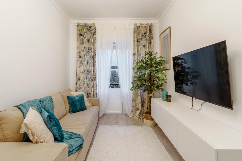 Una sala de estar con un sofá y un televisor de pantalla plana. en Apartamento Goa, en Amadora