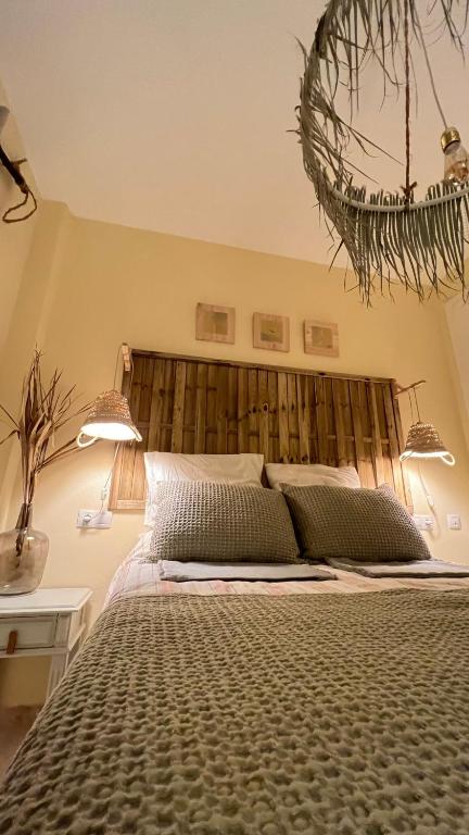 a bedroom with a large bed with a wooden headboard at Casa Pez in Ayamonte