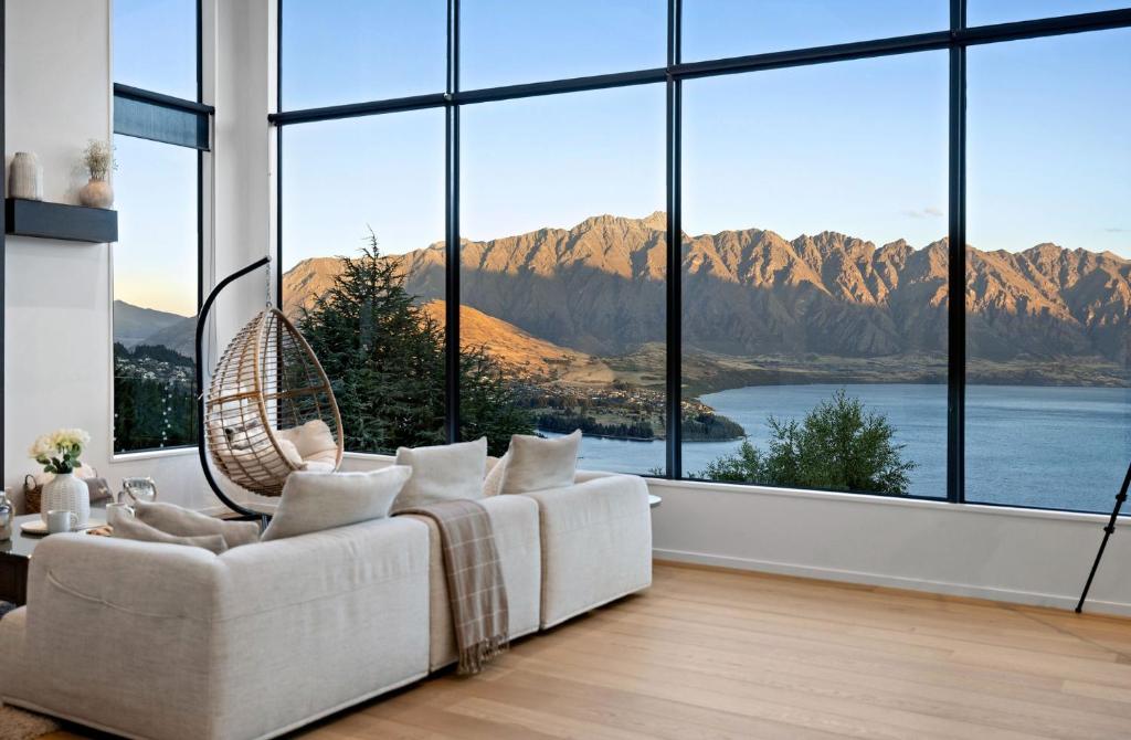 a living room with a white couch and large windows at Vanda Heights in Queenstown