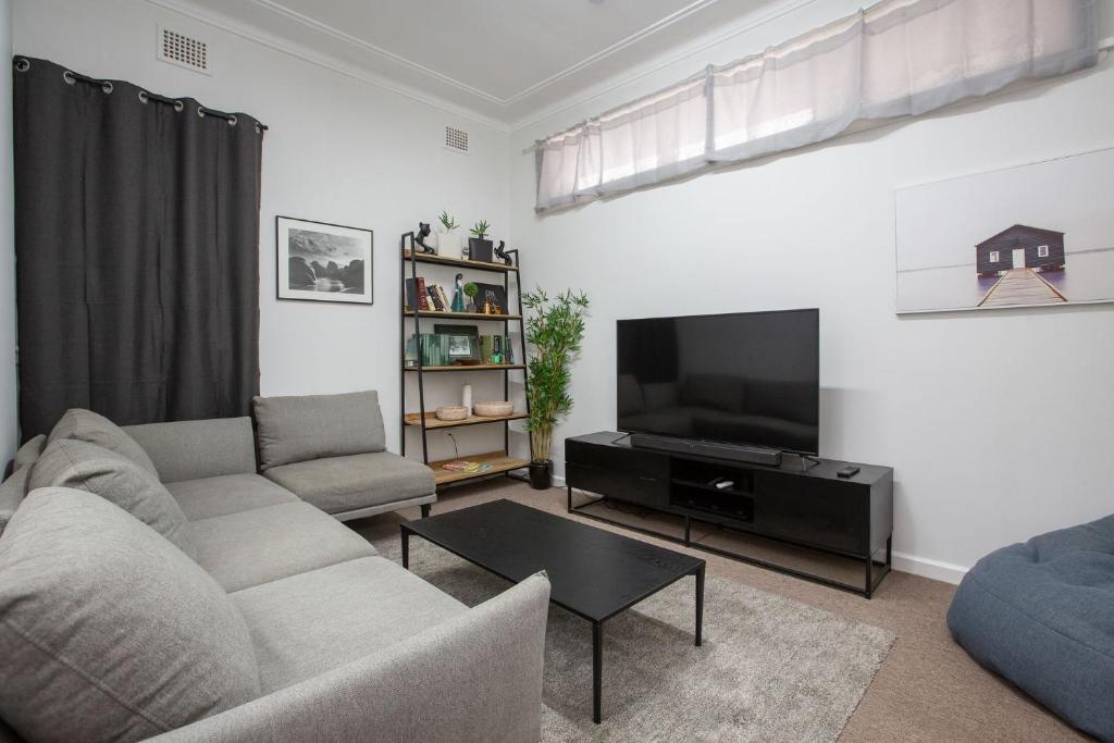 a living room with a couch and a flat screen tv at CitySide Pad in Tamworth