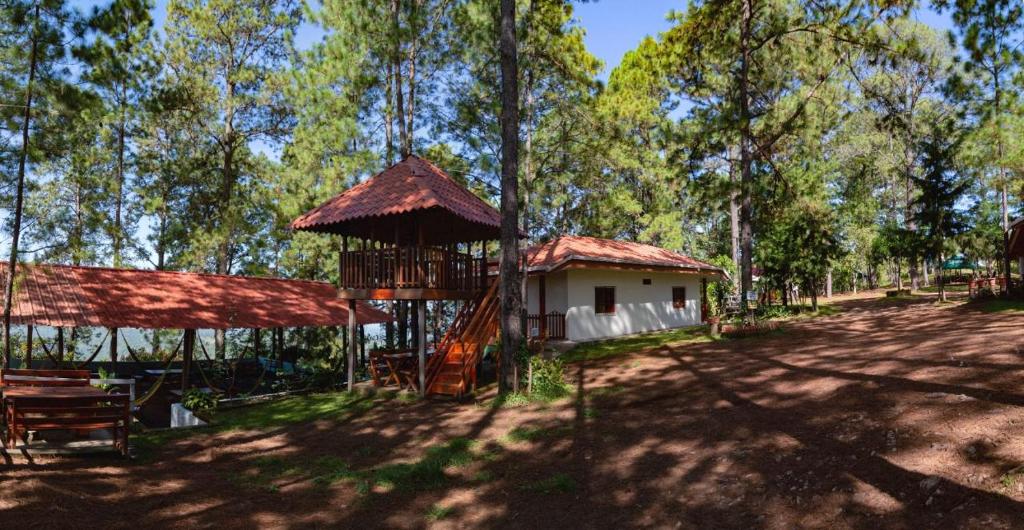 una casa en el árbol con un columpio y un parque infantil en Cabañas y Mirador El Pericón en Arambala