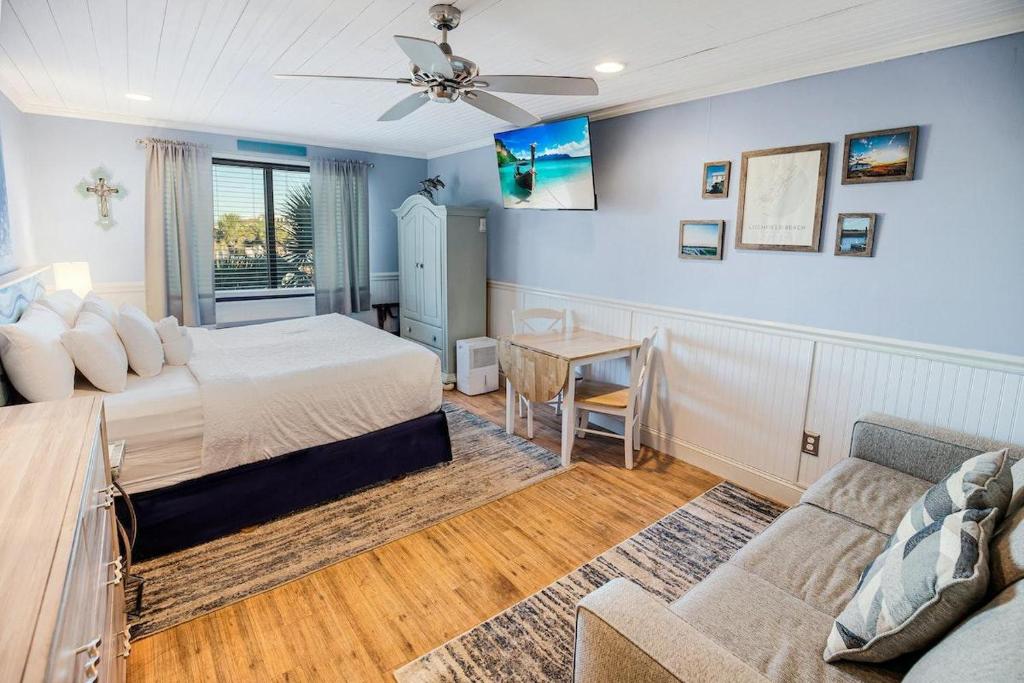 a bedroom with a bed and a couch and a table at Tranquil 3rd Flr Resort View King Room in Pawleys Island